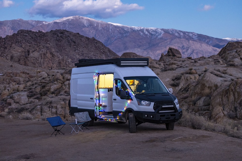 a van parked in the desert with mountains in the background