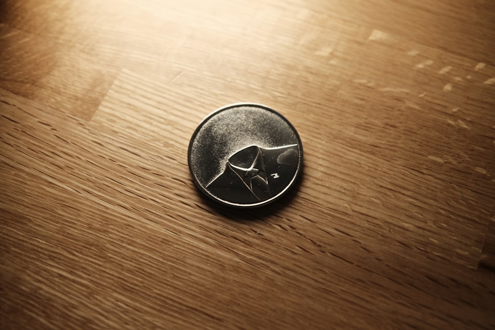 a close up of a button on a wooden surface