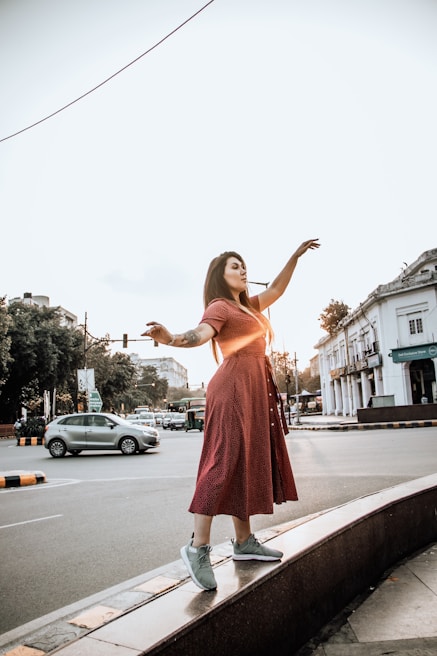 A flowing red dress catching the light in an urban rooftop setting at sunset