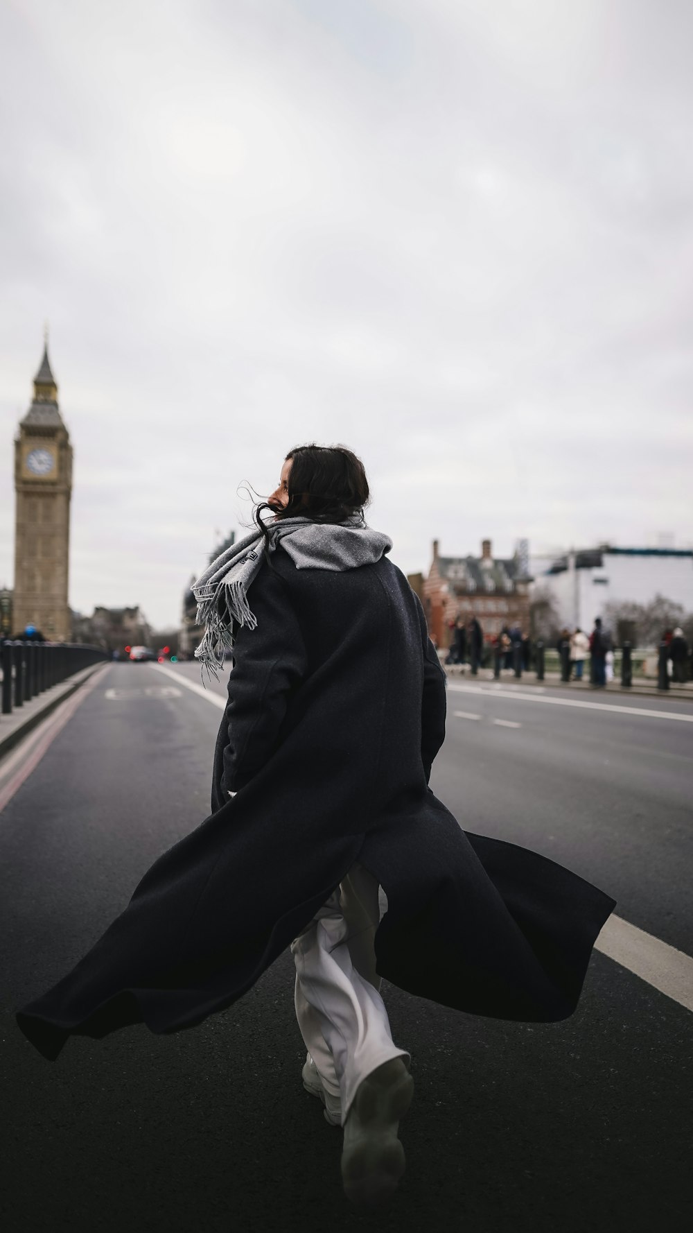 a person walking down a street with a clock tower in the background