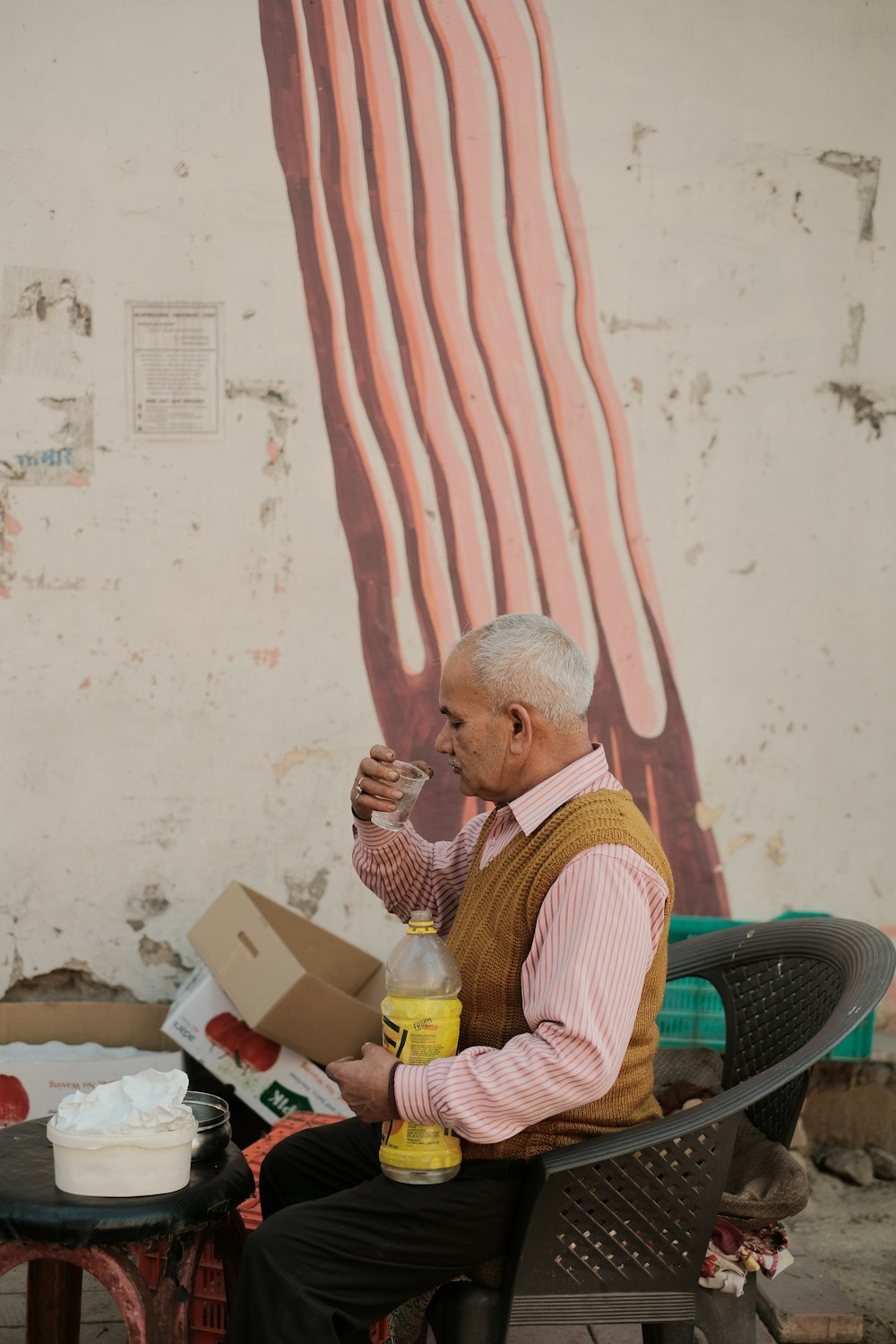 a man sitting on a chair drinking a beverage