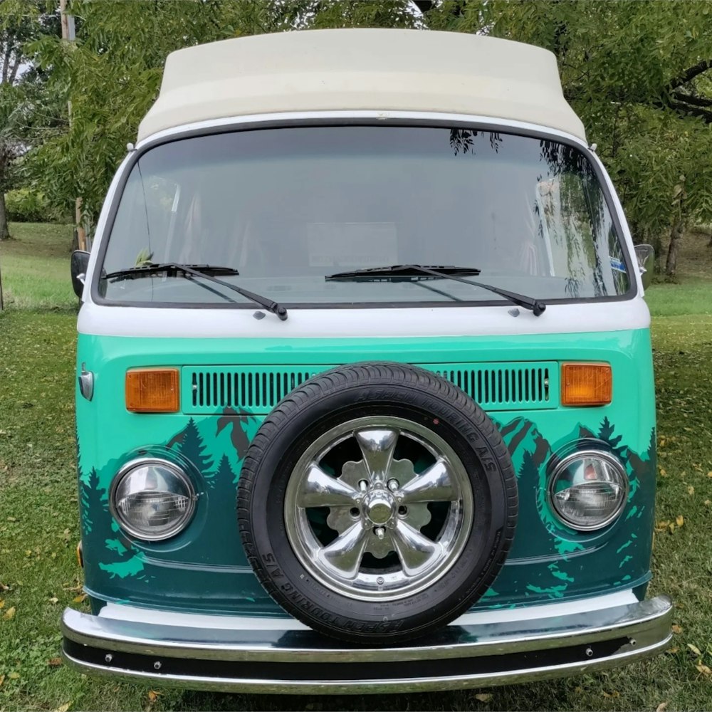 a blue and white van parked on top of a grass covered field