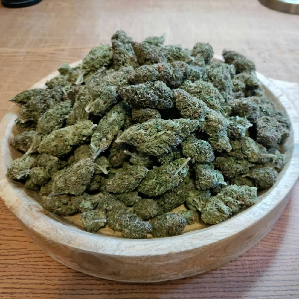 a wooden bowl filled with lots of green stuff