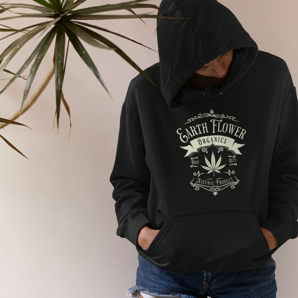 a person wearing a black hoodie with a marijuana leaf on it