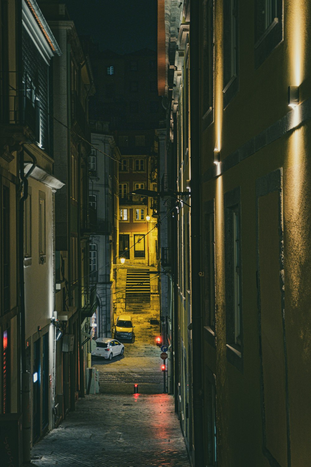 a narrow alley way with cars parked on both sides