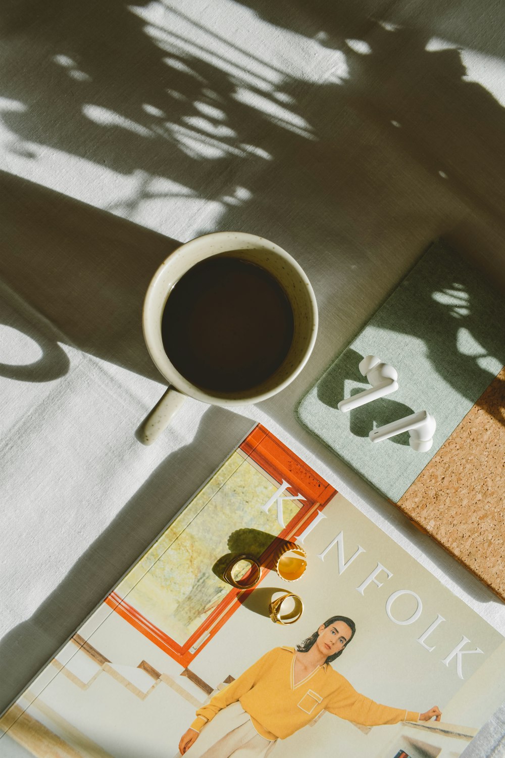 a cup of coffee sitting on top of a table next to a magazine