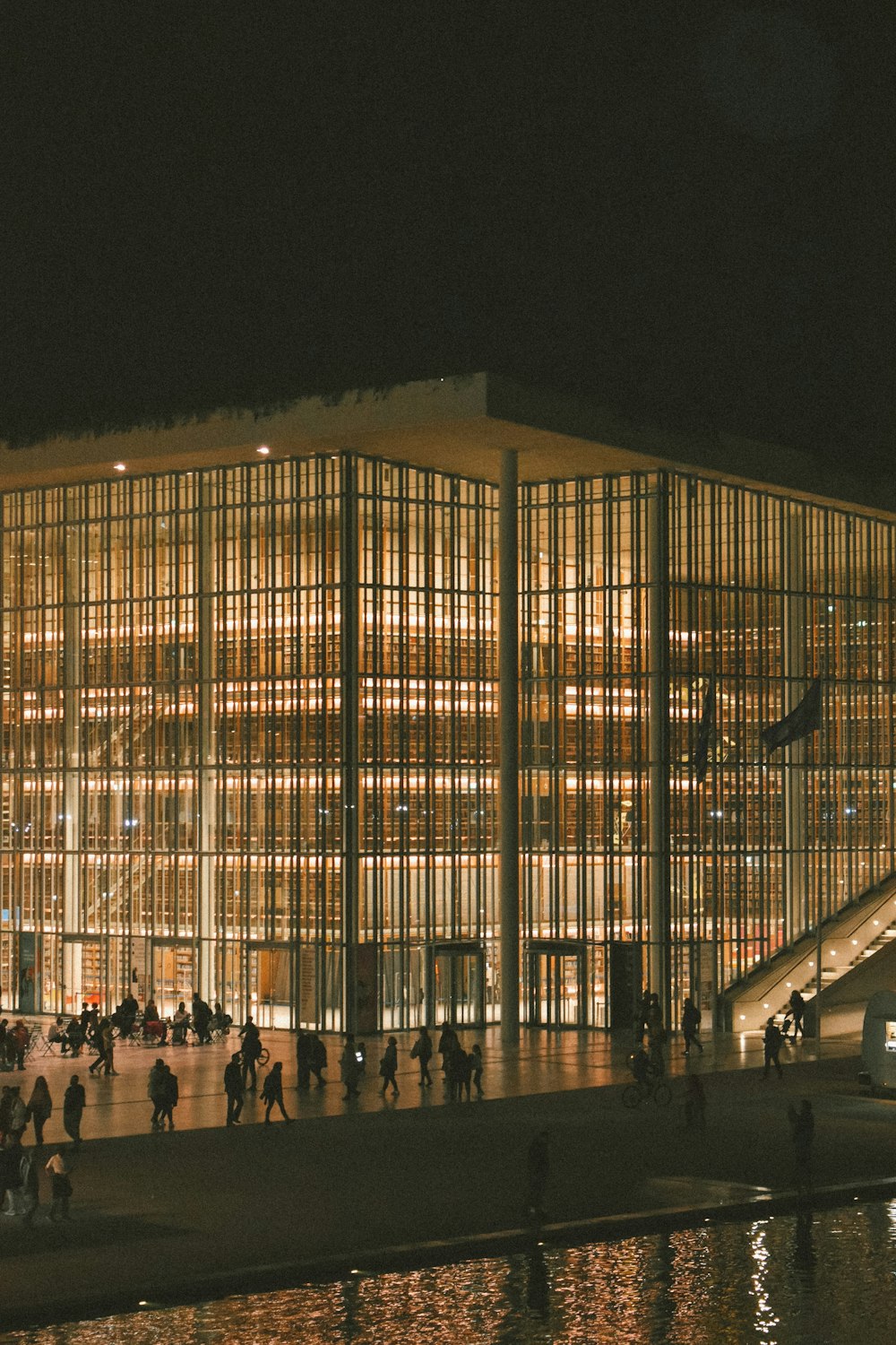 a group of people standing outside of a building at night