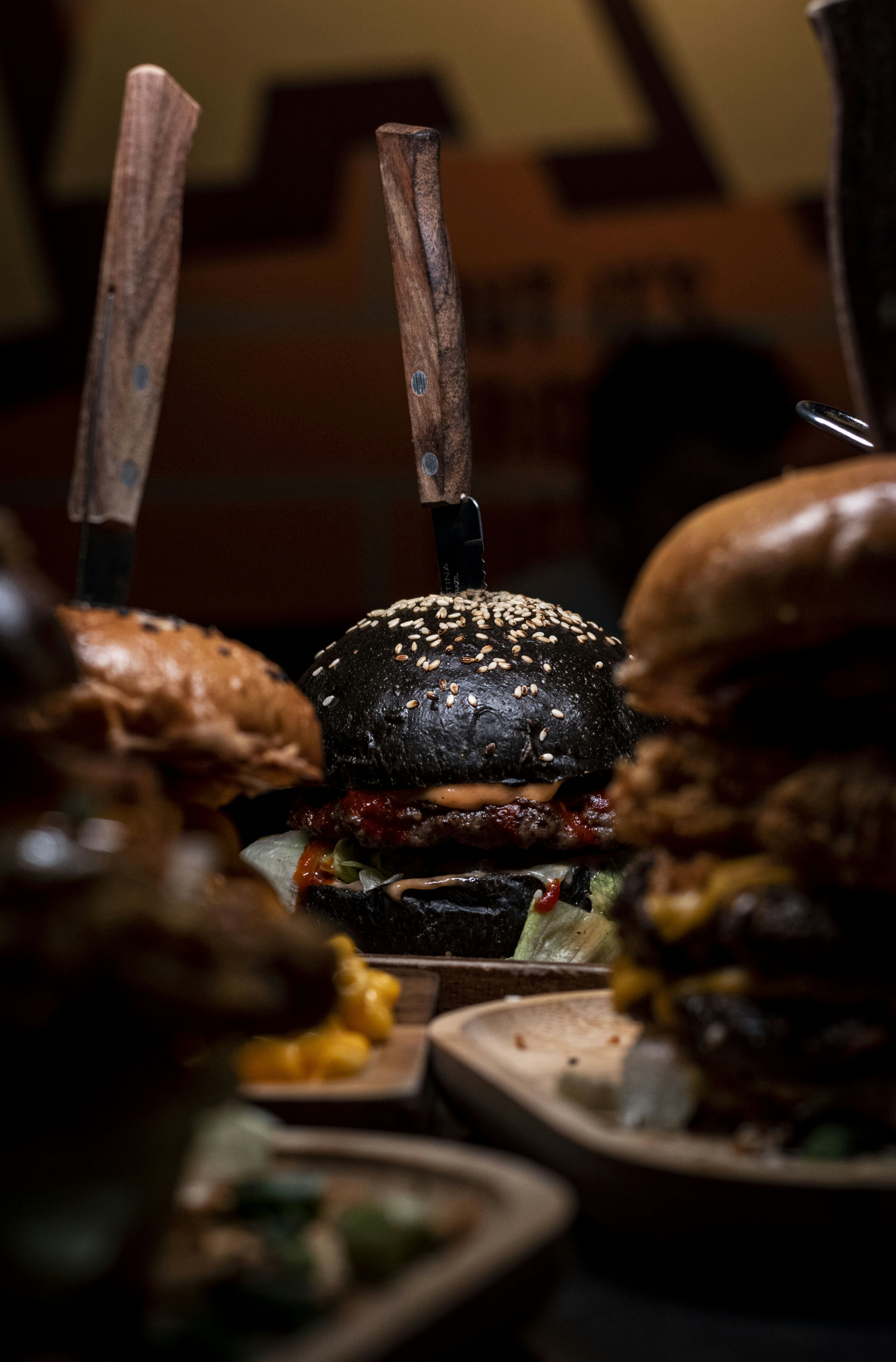 a table topped with lots of hamburgers covered in toppings