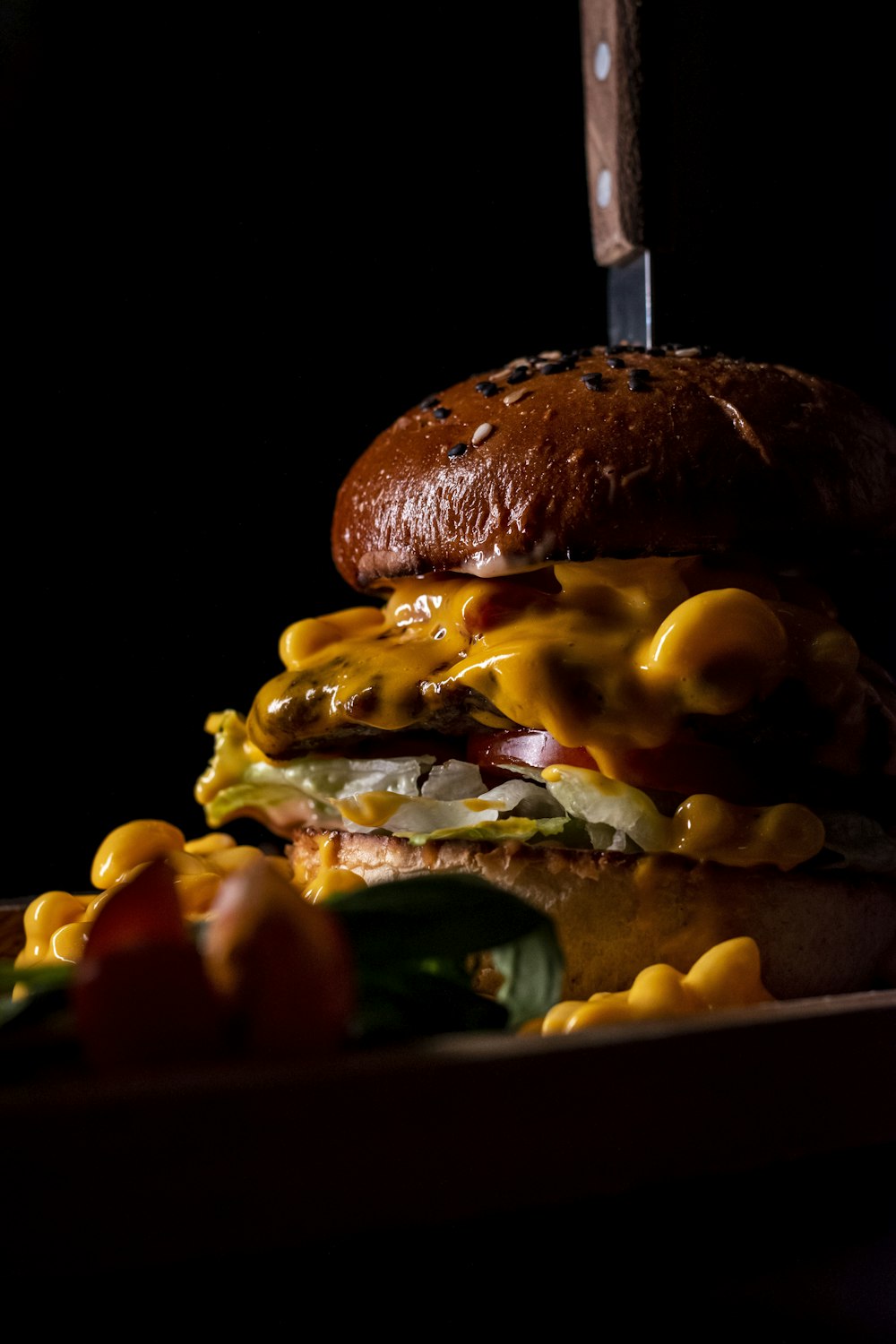 a cheeseburger on a plate with a knife stuck in it