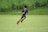 Young athlete sprinting intensely on a soccer field during a training session.