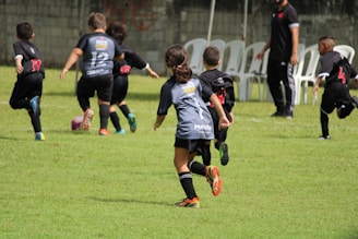 a group of young children playing a game of soccer