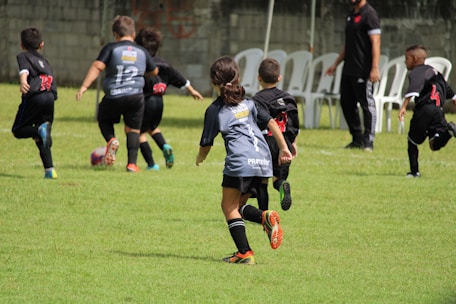 a group of young children playing a game of soccer