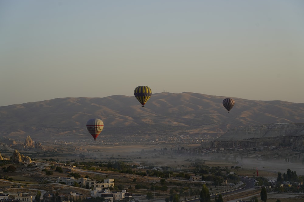 a group of hot air balloons flying over a city