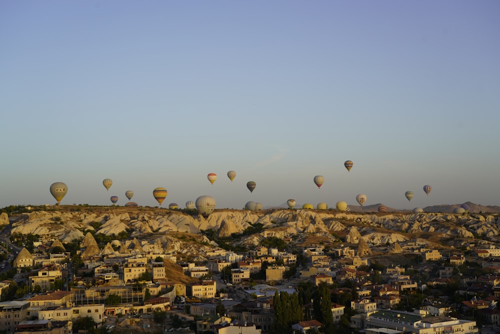 a group of hot air balloons flying over a city