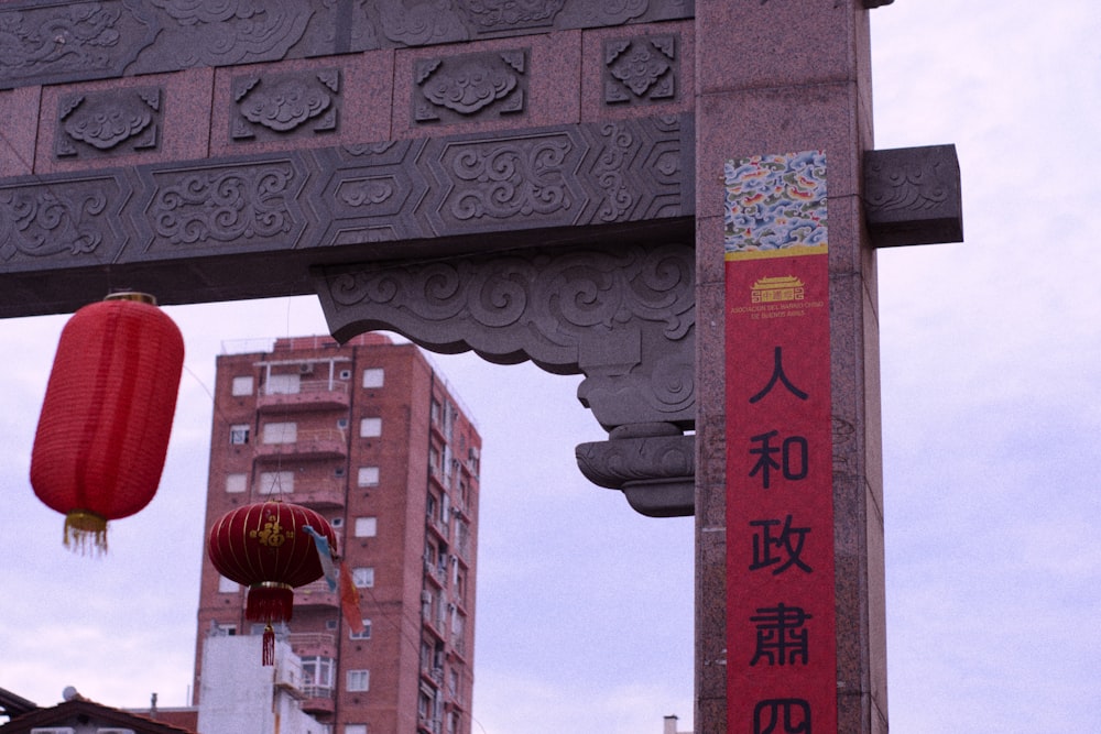 Ein hohes Gebäude mit einer roten Laterne, die an der Seite hängt