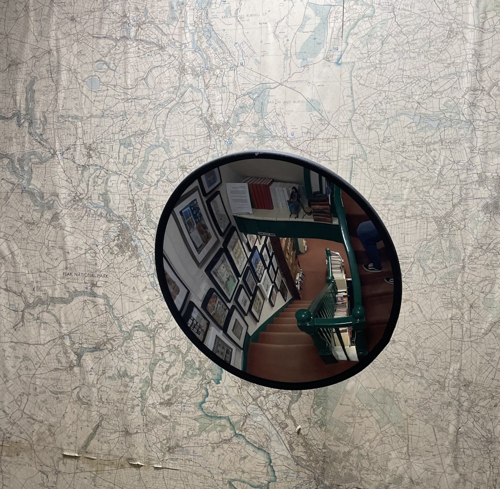 un espejo que refleja una habitación con un mapa en la pared