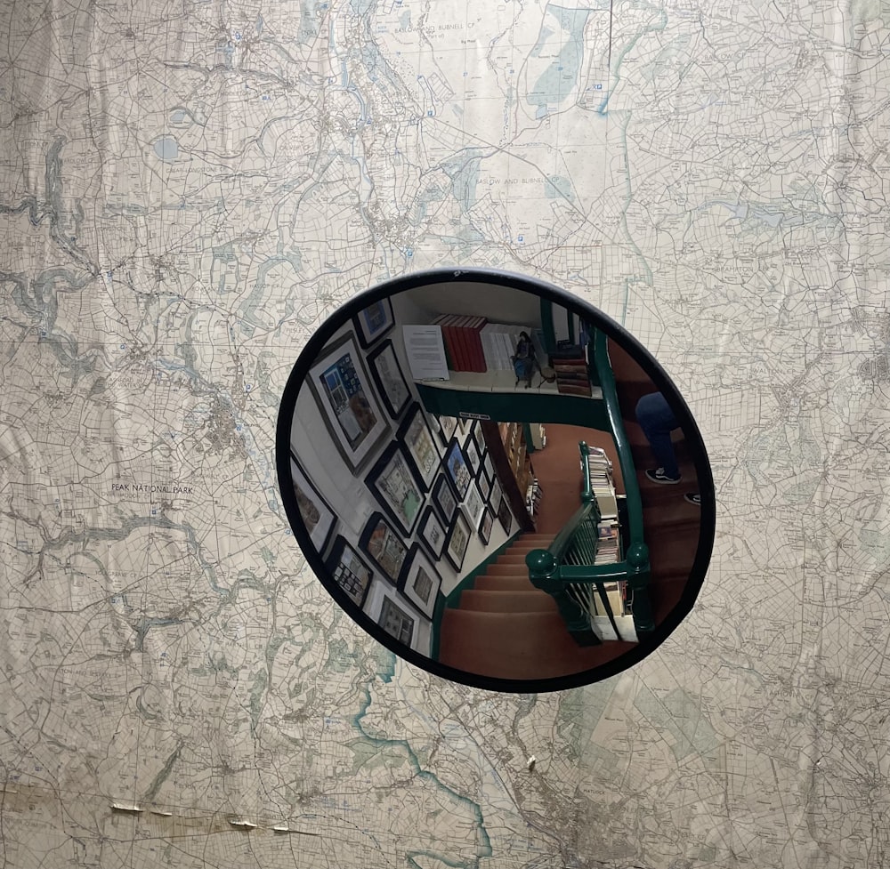 a mirror reflecting a room with a map on the wall