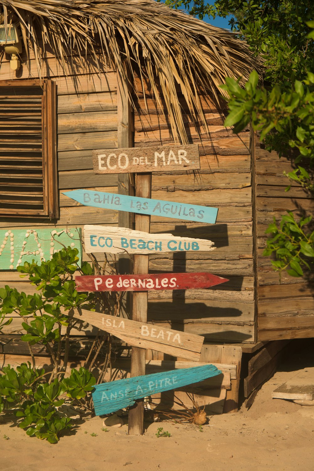 a wooden building with a thatched roof and a sign that says eco del mar