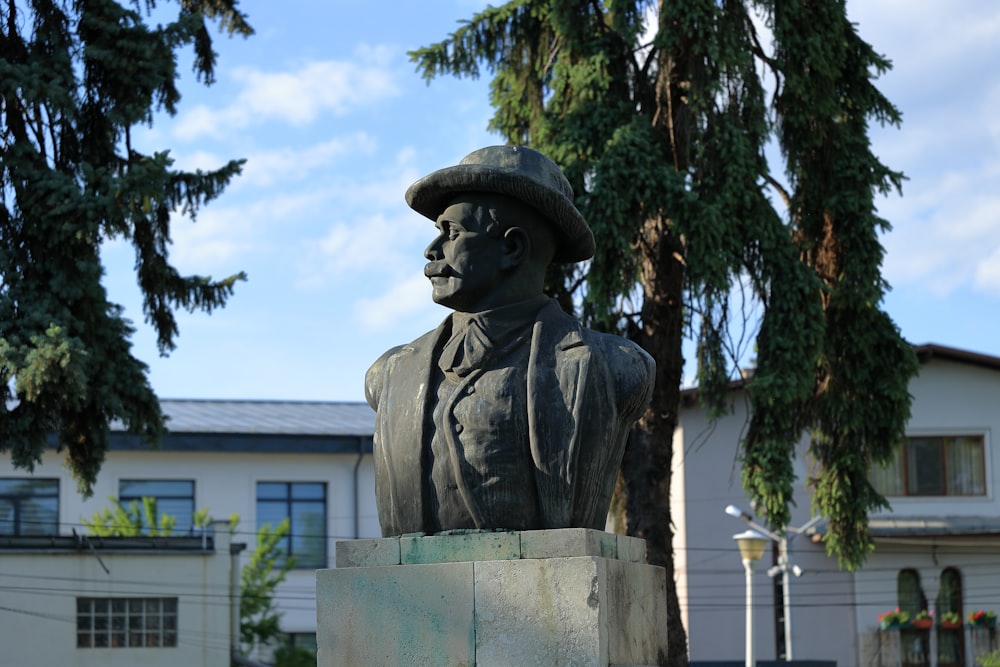 une statue d’un homme portant un chapeau et un manteau
