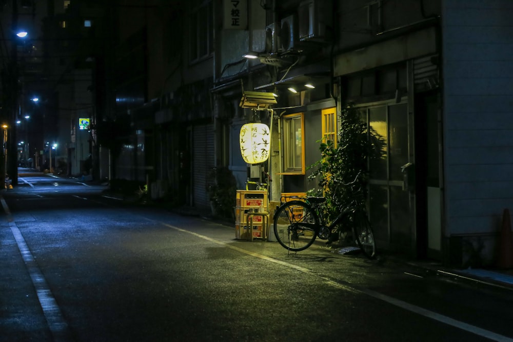 a bike parked on the side of a street at night