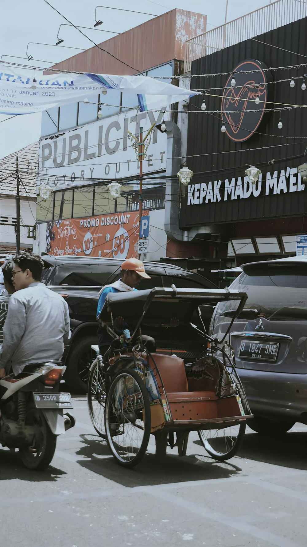 a man riding a motorcycle next to a car