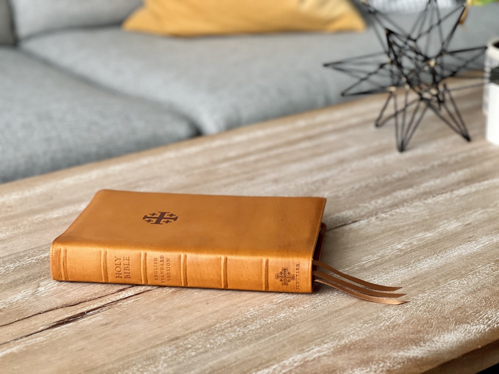 un livre brun posé sur une table en bois