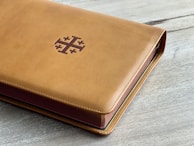 Close-up of a weathered leather-bound book with cryptic symbols embossed on the cover.