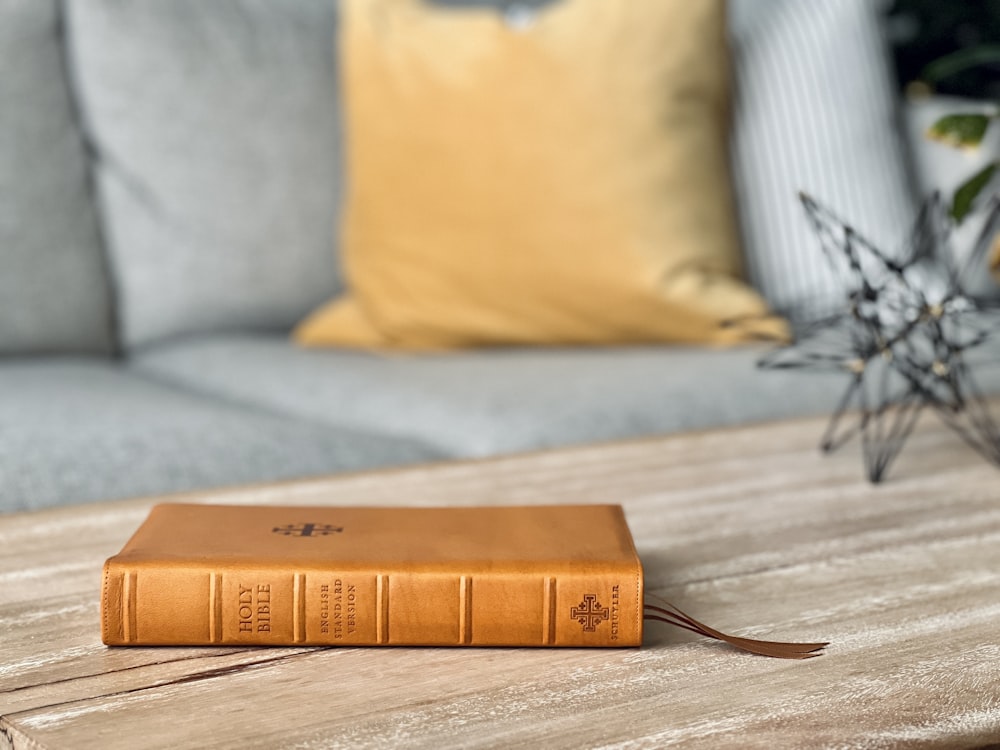 um livro marrom sentado em cima de uma mesa de madeira