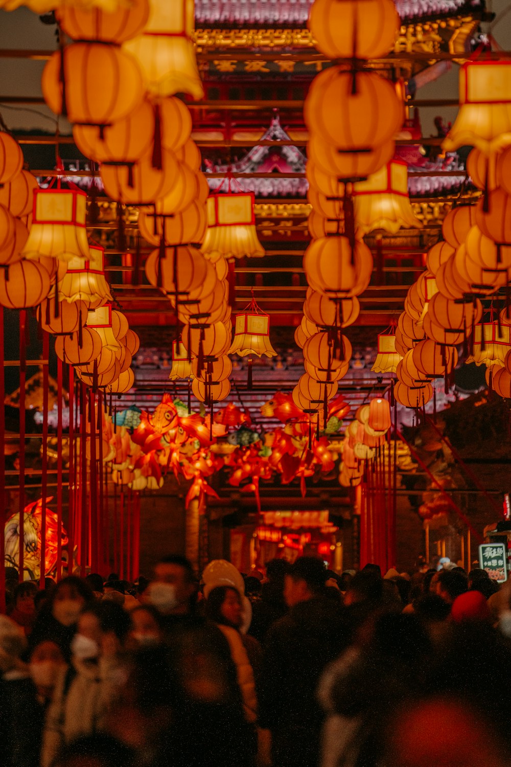 a large group of people standing under lanterns