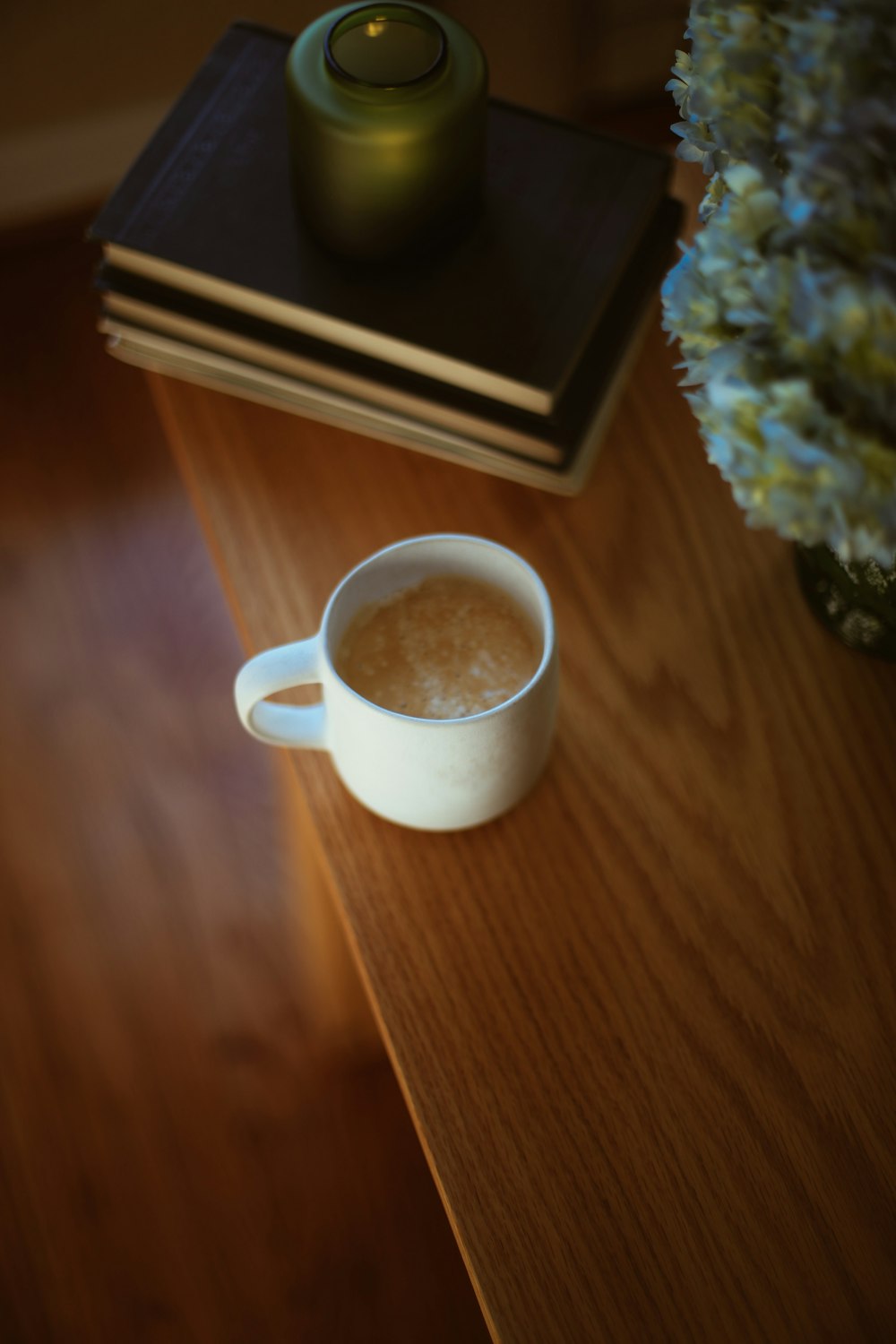 uma xícara de café sentada em cima de uma mesa de madeira