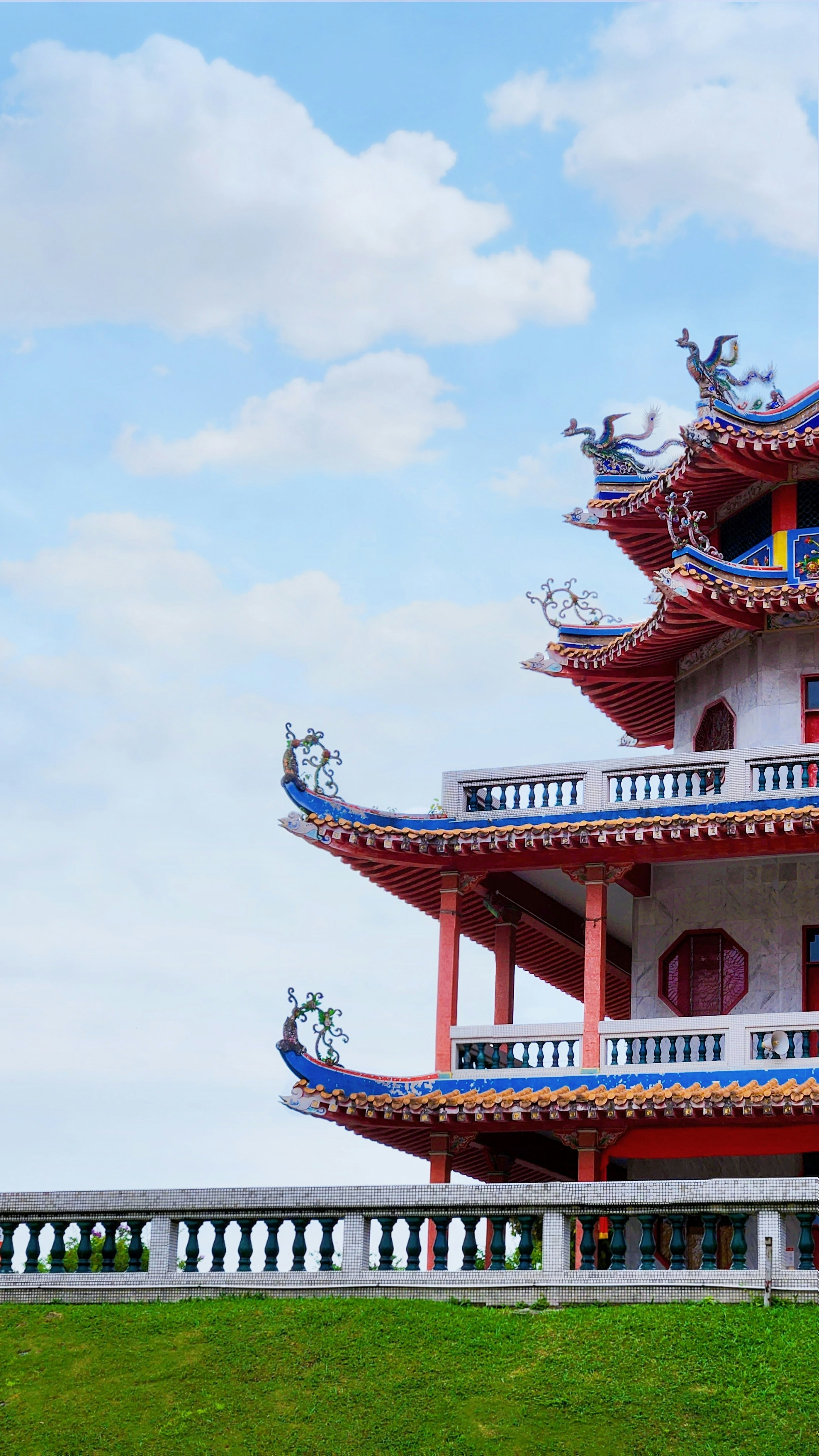 a red and white building sitting on top of a lush green field