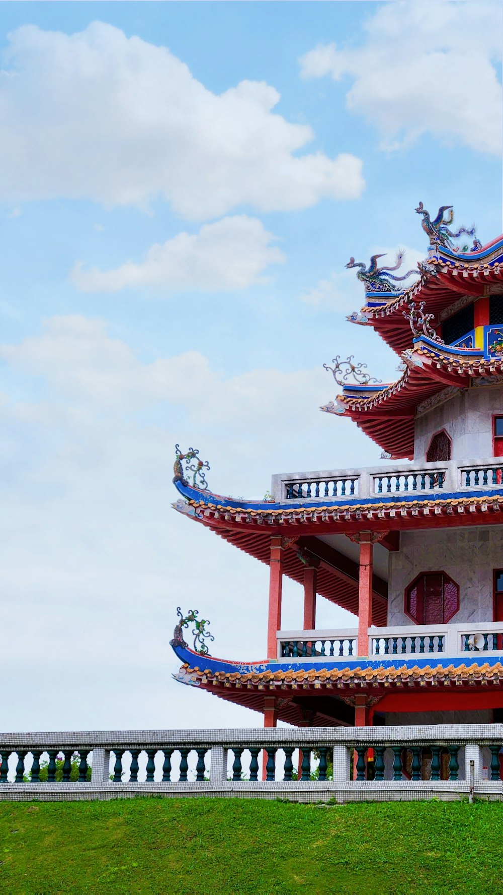 a red and white building sitting on top of a lush green field