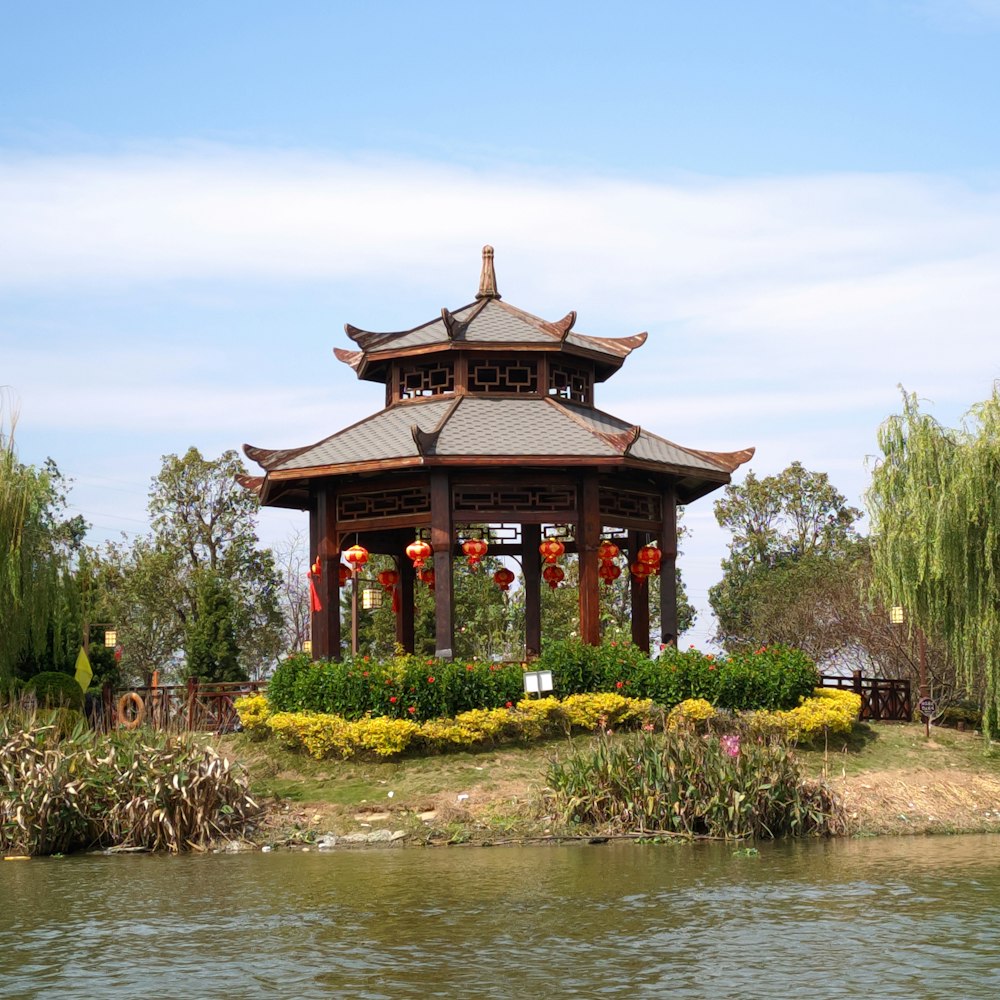 a gazebo sitting on top of a lush green field next to a lake