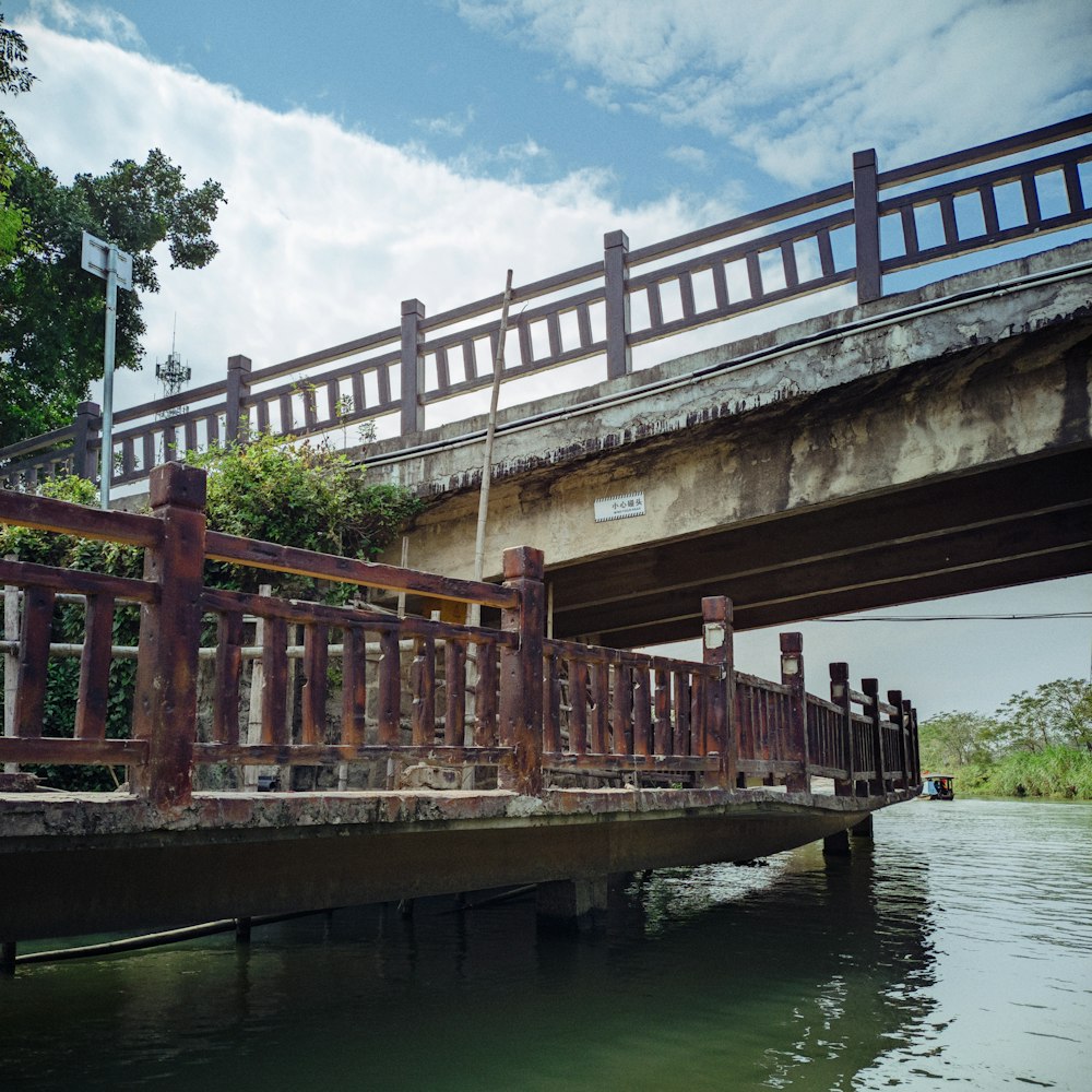 a bridge over a body of water next to a lush green forest