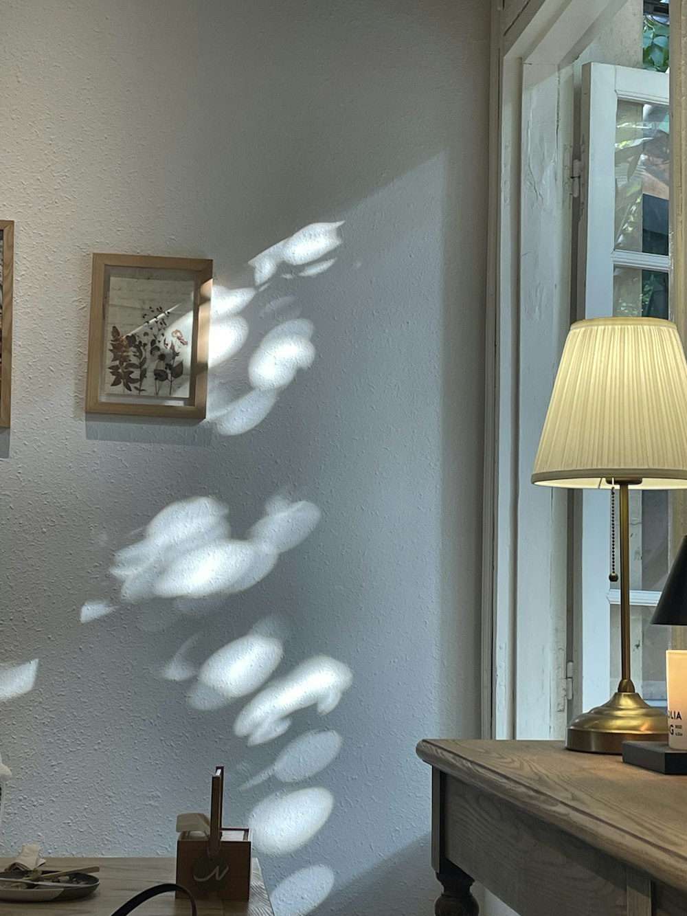 a desk with a lamp and pictures on the wall