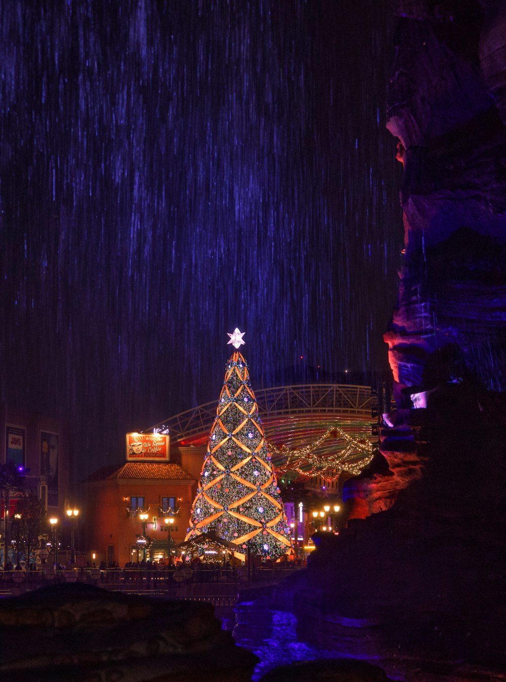 a lit up christmas tree in the rain