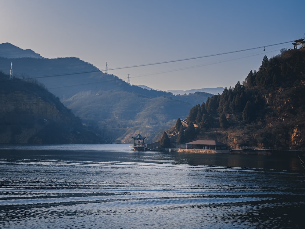 a boat traveling down a river with mountains in the background