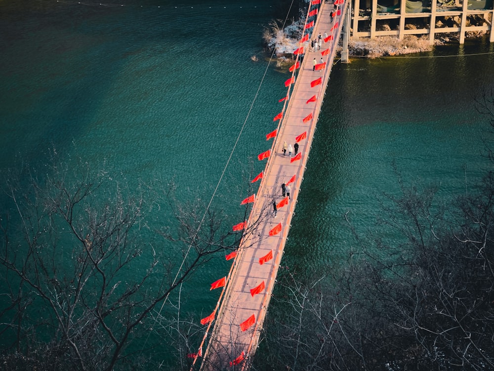 a long bridge with red flags on it