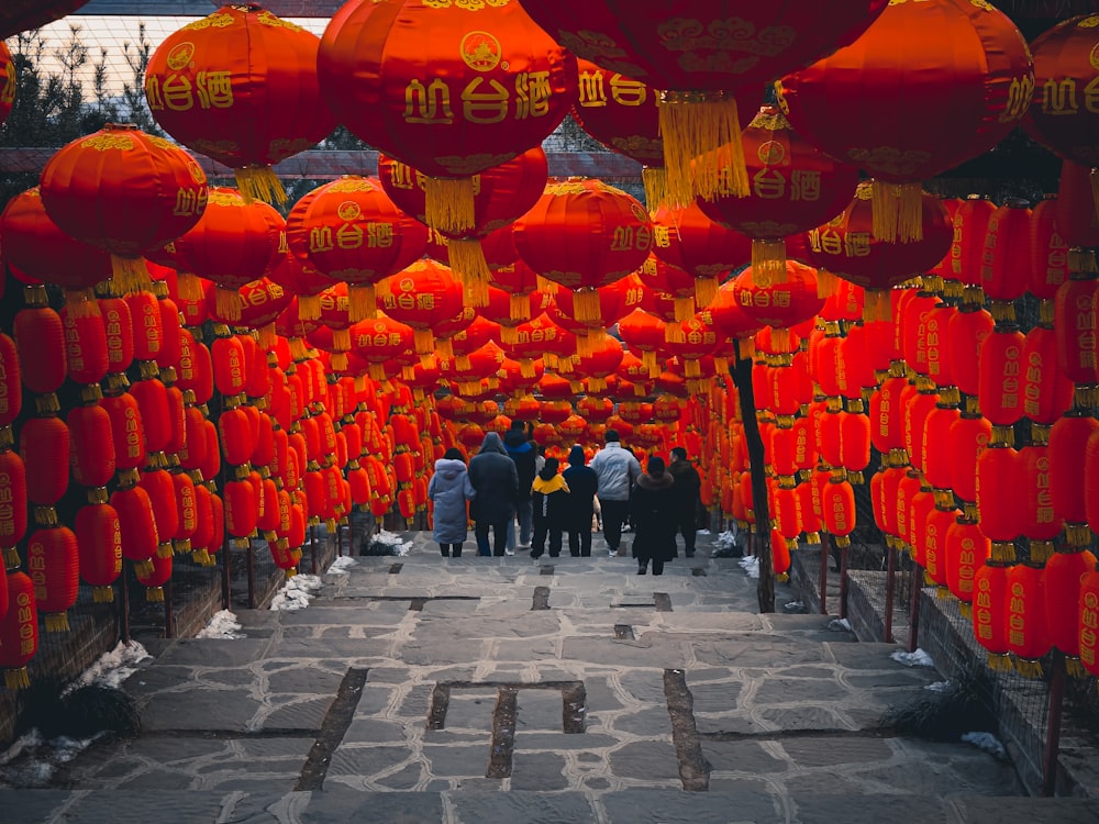 a group of people standing under red lanterns