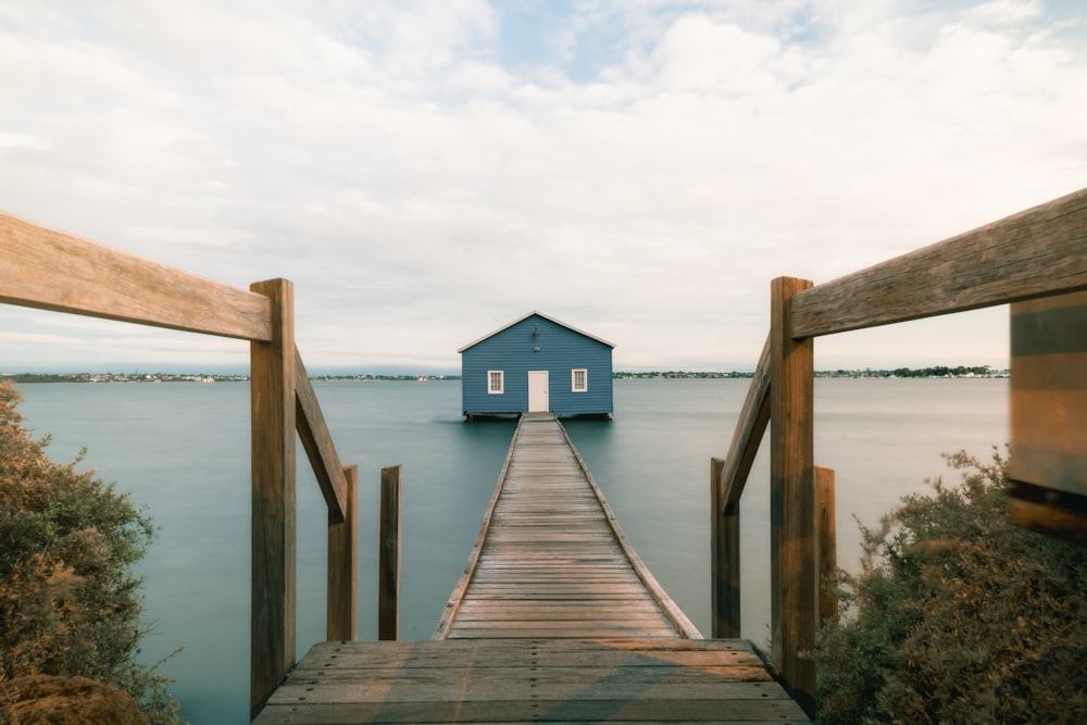 a dock with a small blue house on it