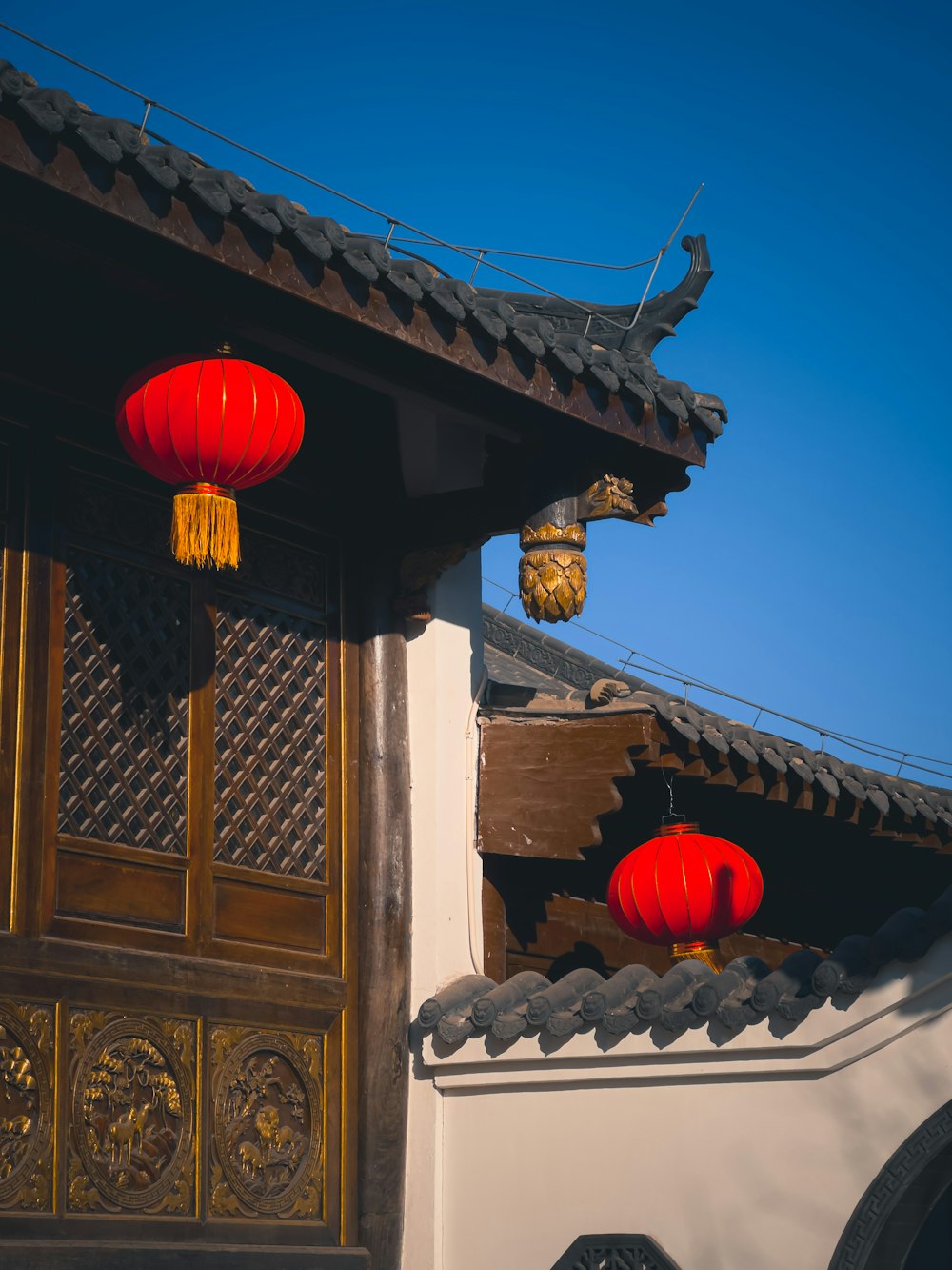 a building with two red lanterns hanging from it's roof