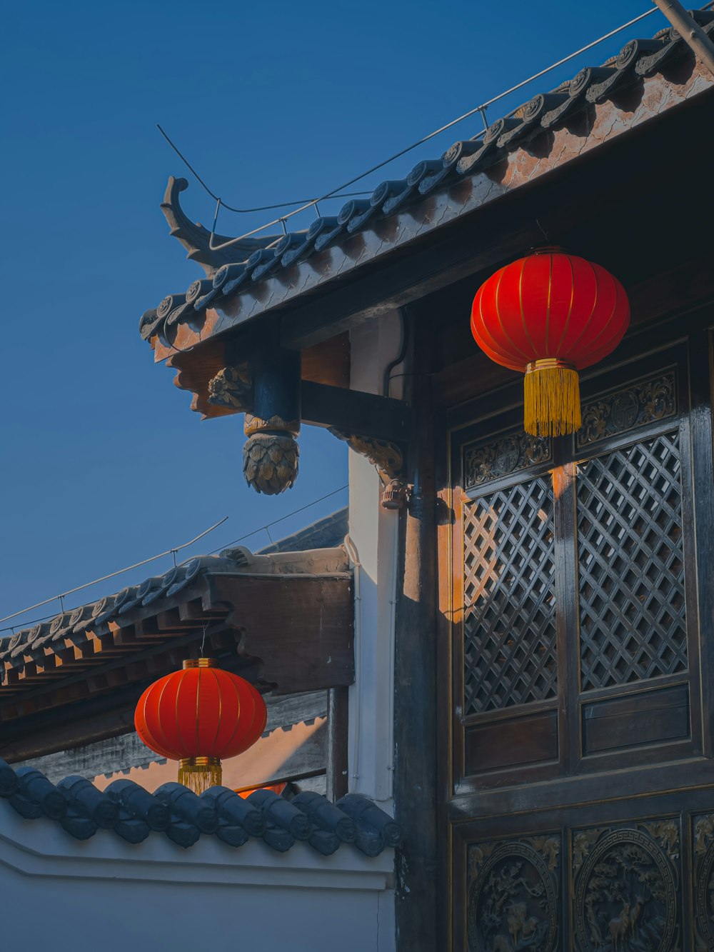 a couple of red lanterns hanging from the side of a building