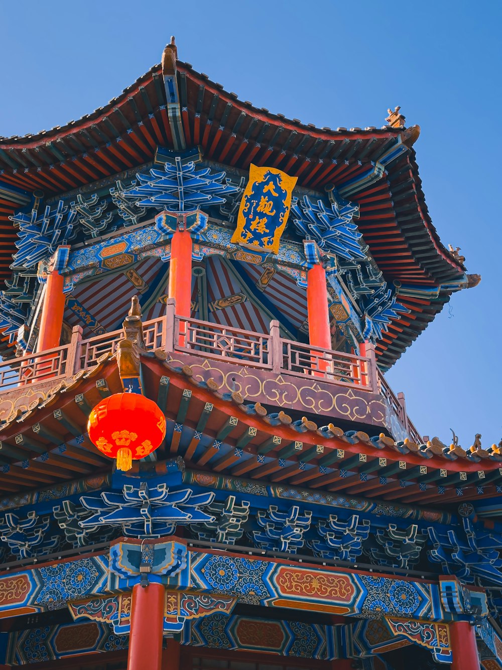 a tall tower with a red lantern hanging from it's side