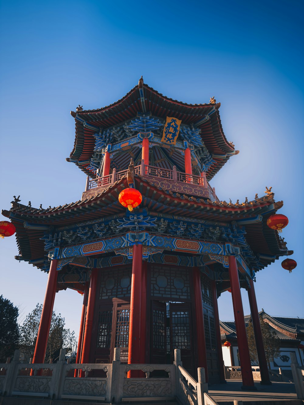 a tall building with a red lantern hanging from it's roof