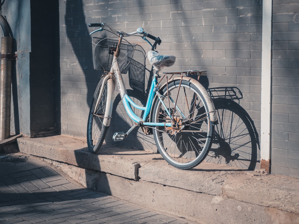 a blue bicycle parked on the side of a building