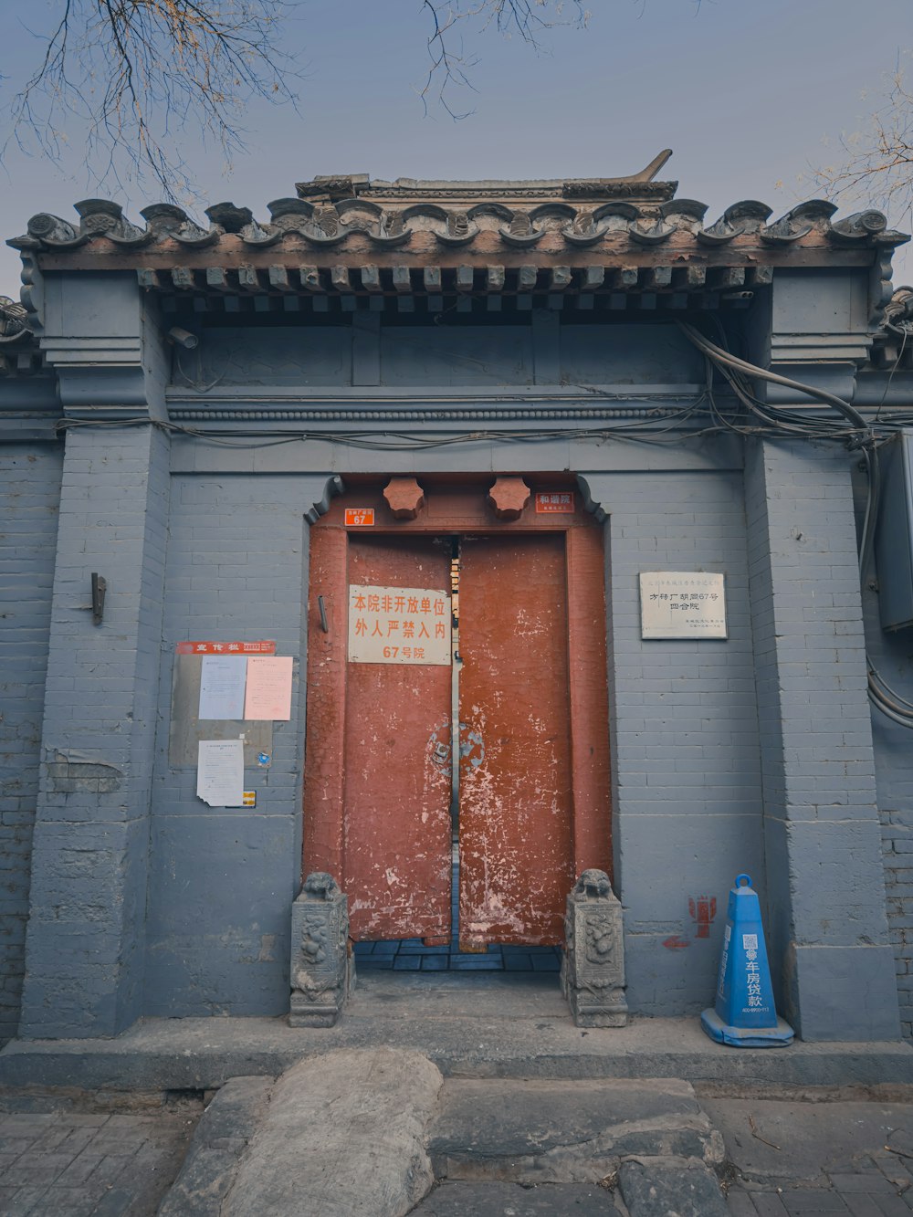 a blue building with a red door and a blue cone