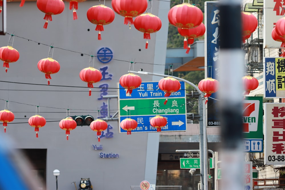 a bunch of red lanterns hanging from the side of a building