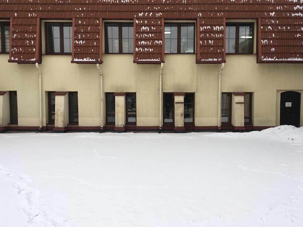 a building with brown shutters in the snow