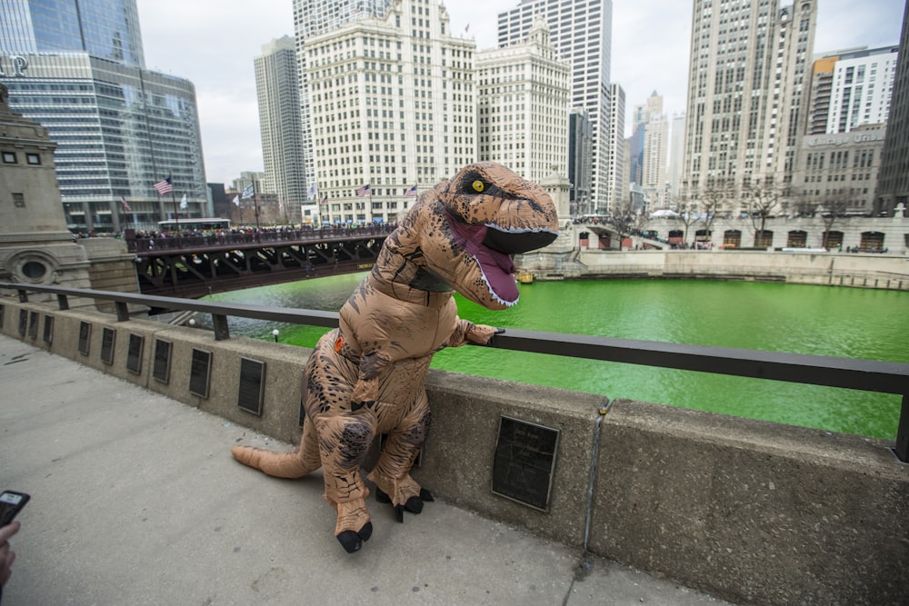 Una persona con un disfraz de dinosaurio inflable en un puente