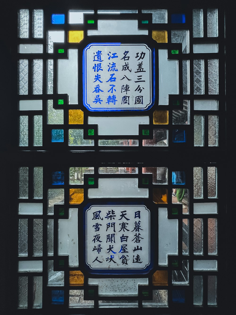 two stained glass windows with asian writing on them